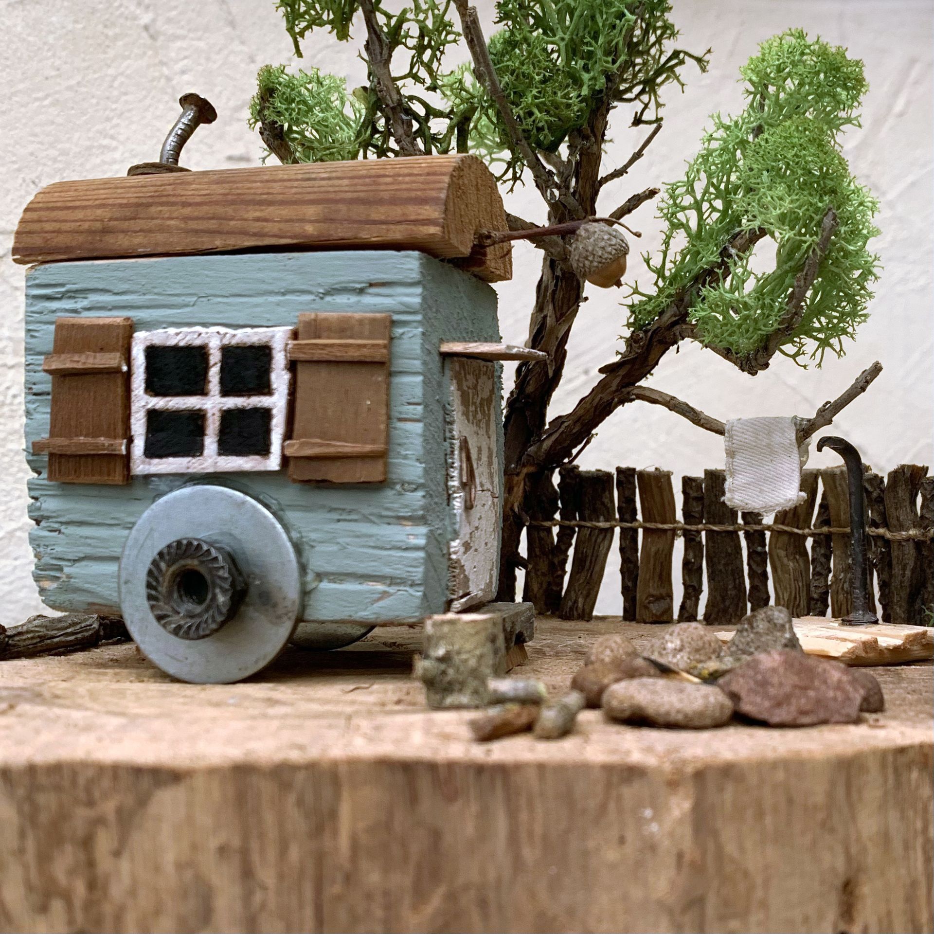 Bauwagenidylle, Miniatur Bauwagen aus Holz auf Baumscheibe, Baum mit Echtmoos, Aussendusche und Feuerstelle