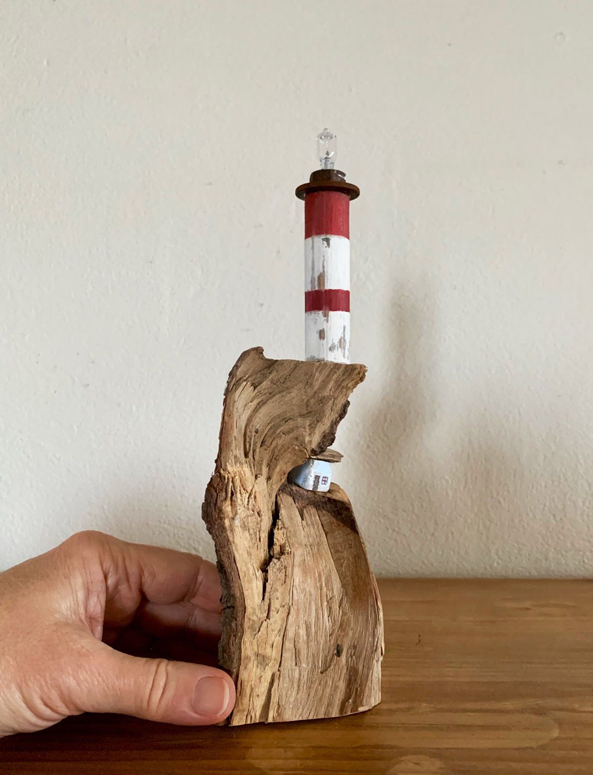 Leuchtturm und Häuschen auf Holzscheit