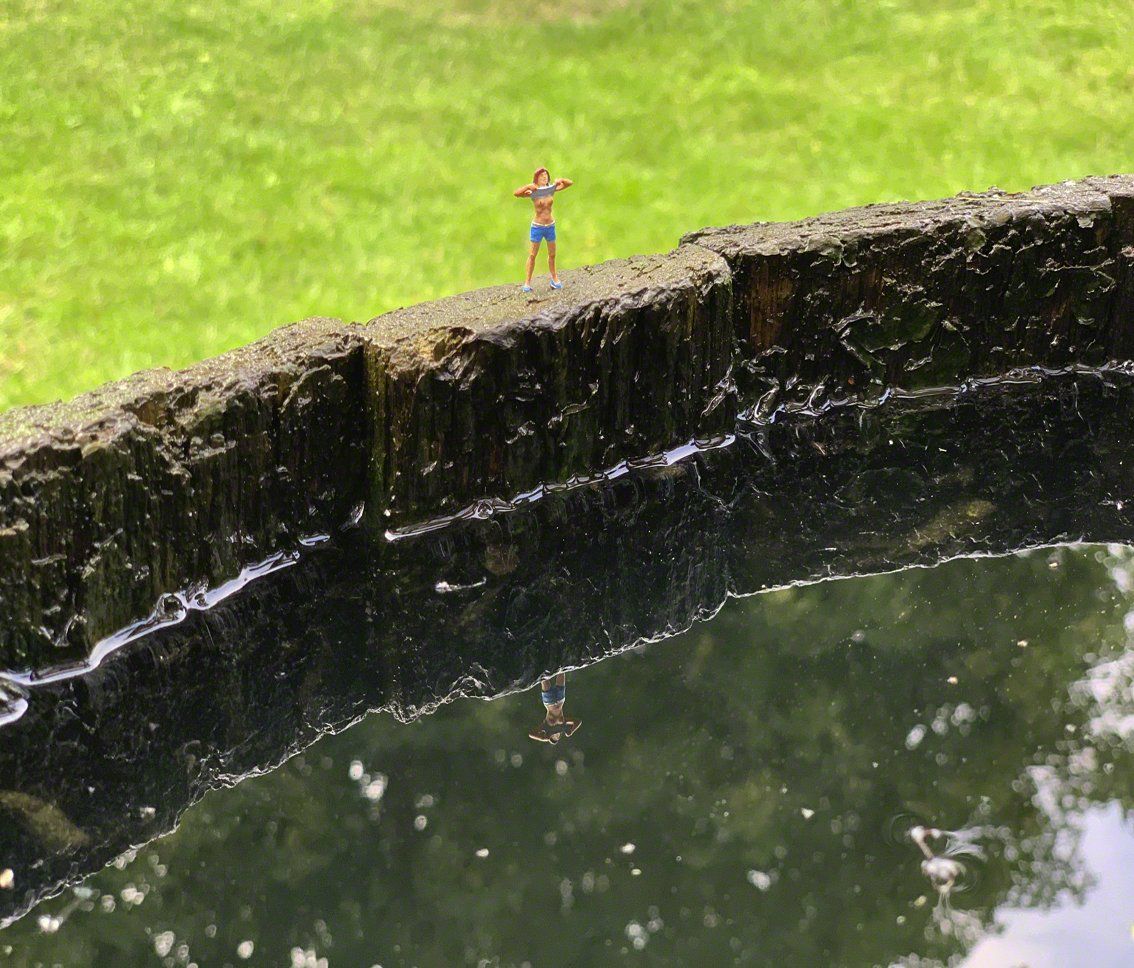 Foto H0-Figur auf Rand von Regentonne