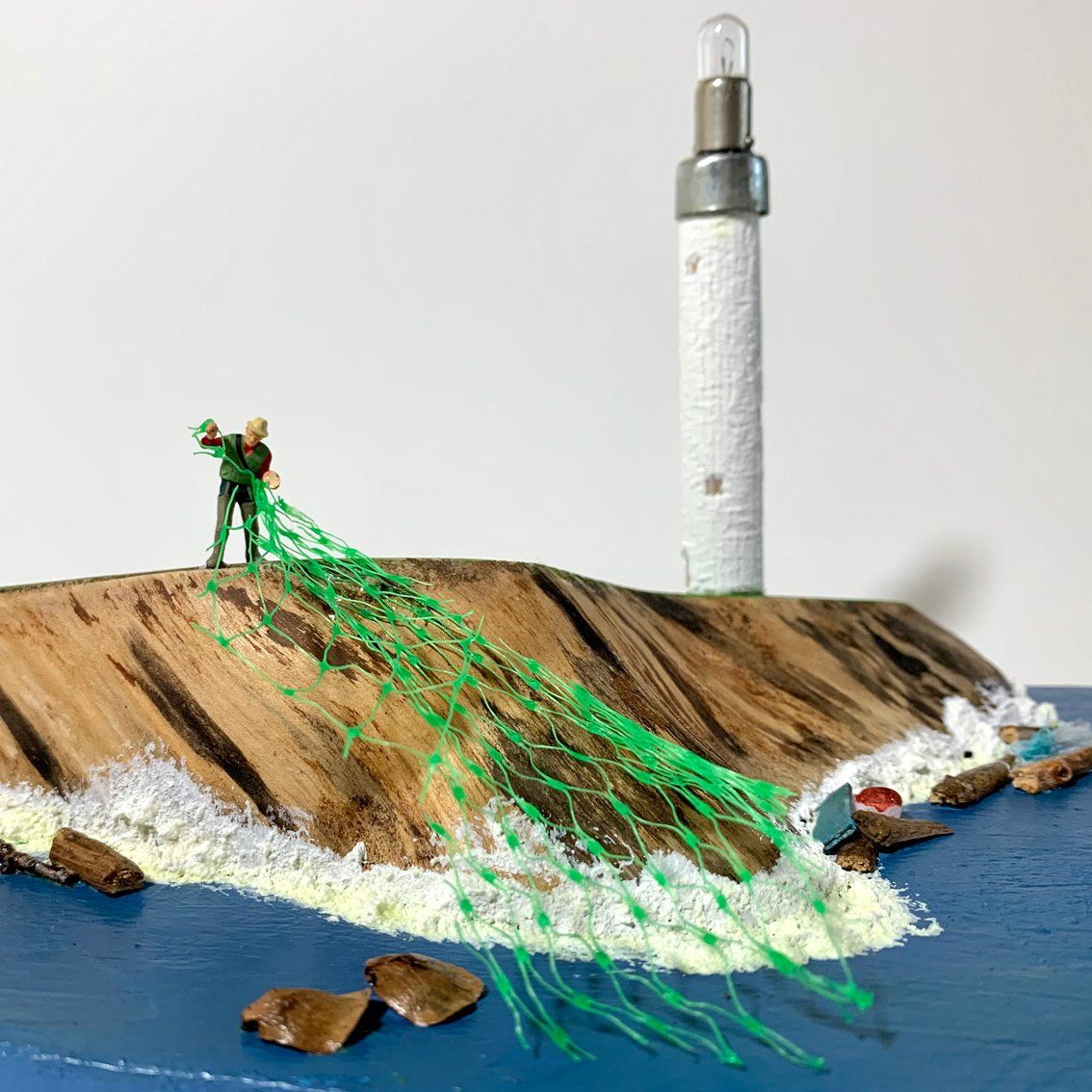 Holzkeil auf Holzplatte und Leuchtturm, mit H0-Figur als Fischer mit Meisenknödel-Netz,Miniaturwelt,Miniaturlandschaft