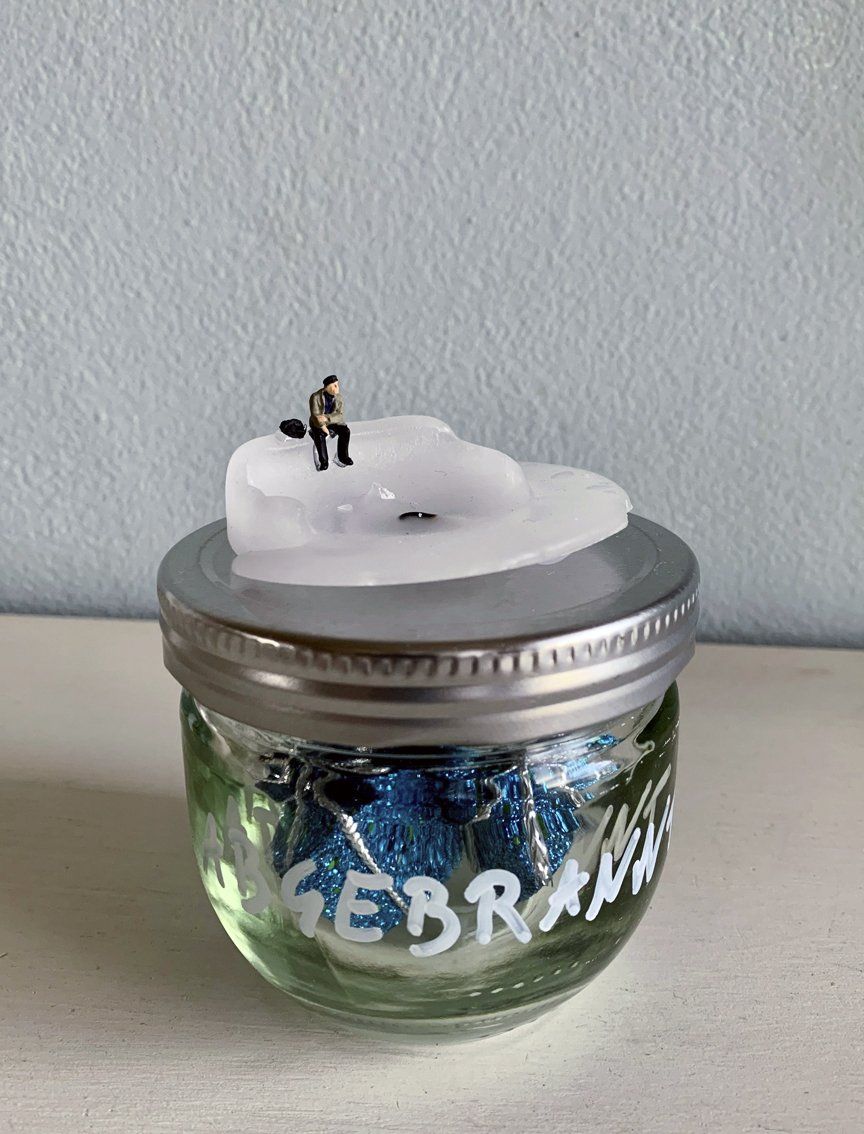 H0 Figur Mann sitzt am Rand von abgebranntem Kerzenstumpen auf Glas mit Aufschrift abgebrannt