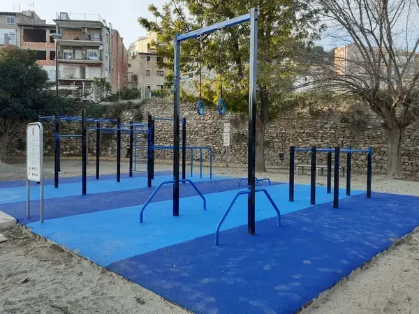 Parque de calistenia exterior azul con estaciones de entrenamiento funcional y anillas deportivas