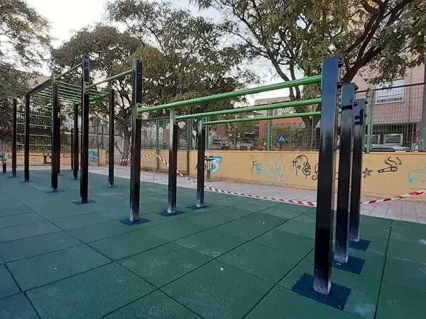 Parque de calistenia con monkey bras, barras paralelas y barras de dominadas sobre suelo de caucho verde de Toxic Workout