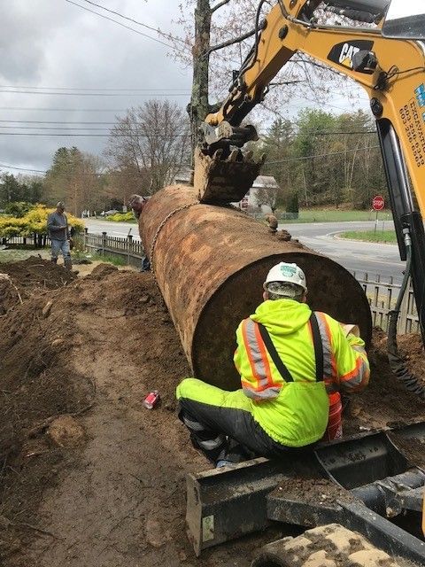 Workmen removing large underground tank