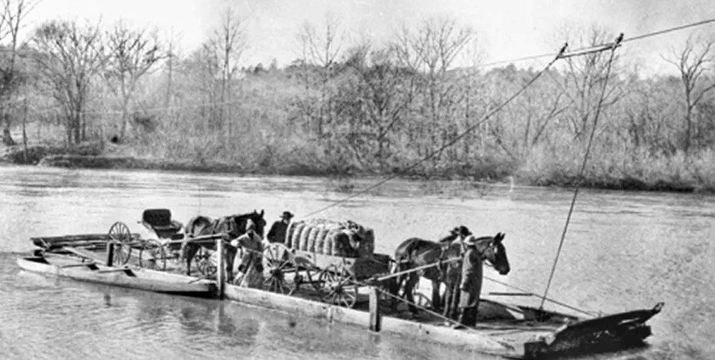 Flatbed boat with wagon and horses being pulled by a overhead rope system
