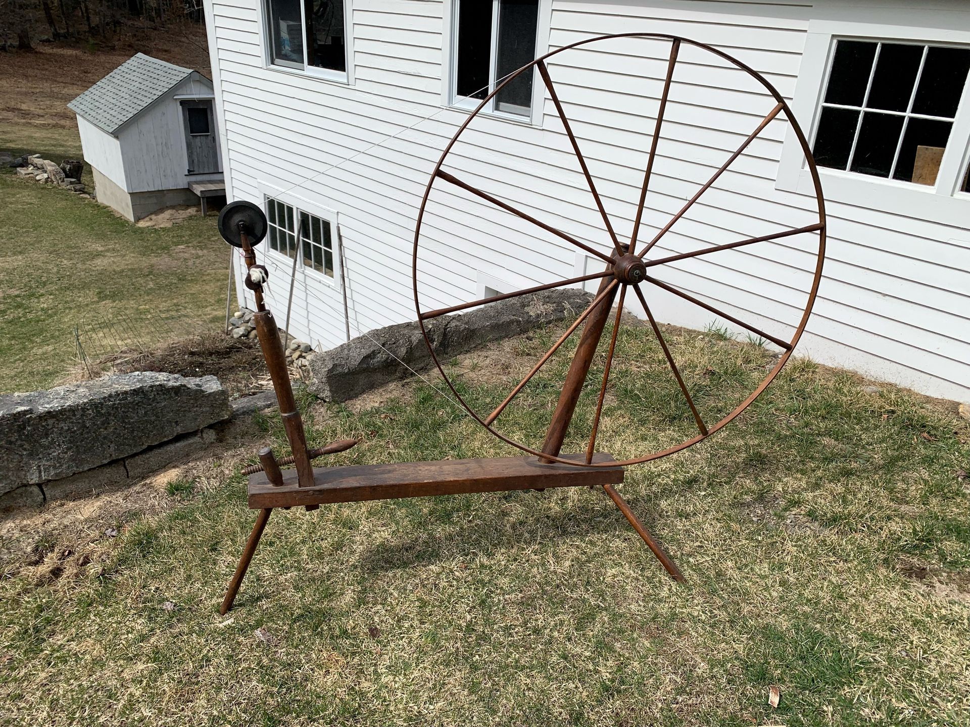 Large wheeled spinning wheel with wool to be turned into yarn