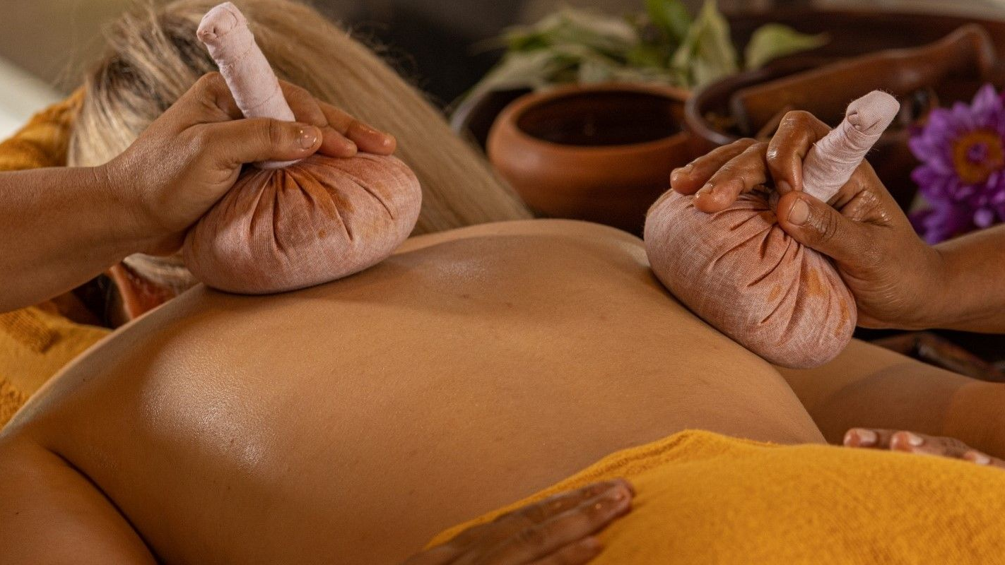 Ayurveda Kuren in Sri Lanka Ayurveda mit Reissäckchen auf dem Rücken einer Frau