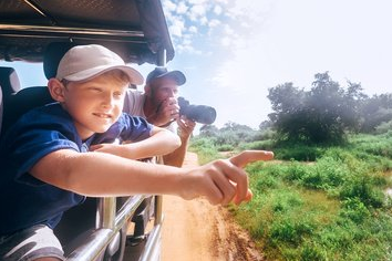 Ausflüge & Safaris Sri Lanka Ein Kind im Jeep weist auf etwas während eines Sri Lanka Safari Ausflugs, der Vater fotografiert. D´Safari Touren mit SriLanka Explorer