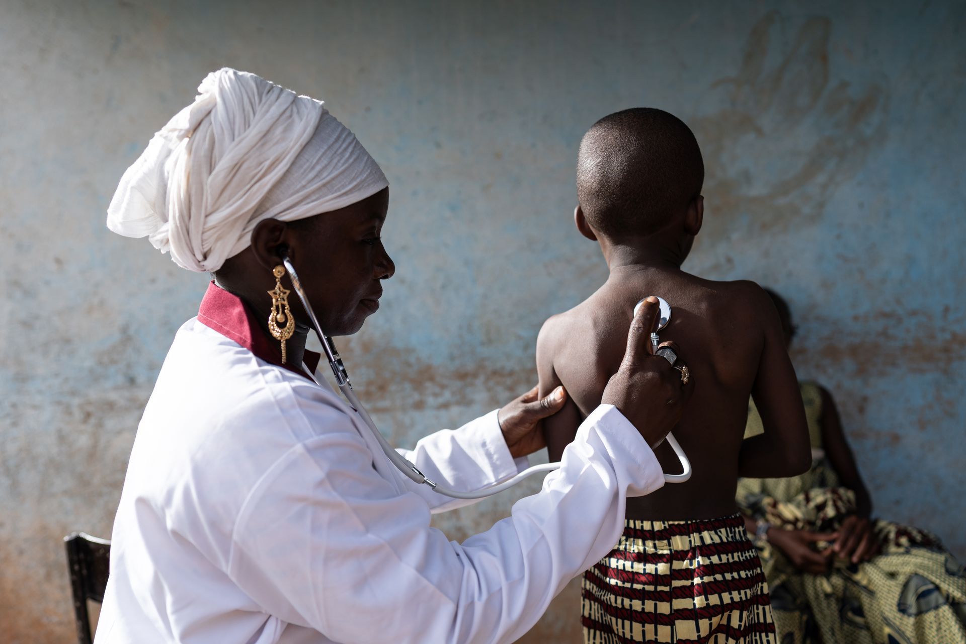 Ärztin horcht ein Kind ab Medizinische Versorgung, Afrika, Ärztin
