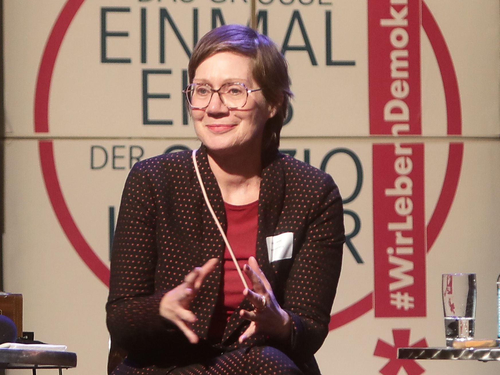 Heike Herold gestikulierend in einer Podiumsdiskussion.
