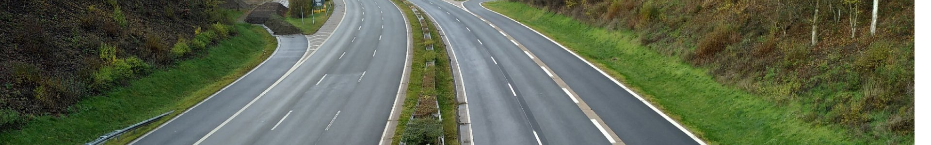 Foto der stillgelegten A 45 von oben auf die Fahrbahn. Es fahren keine Autos, rechts und links sind grüne Bäume und Büsche, links türmen sich Erdhübbel auf.