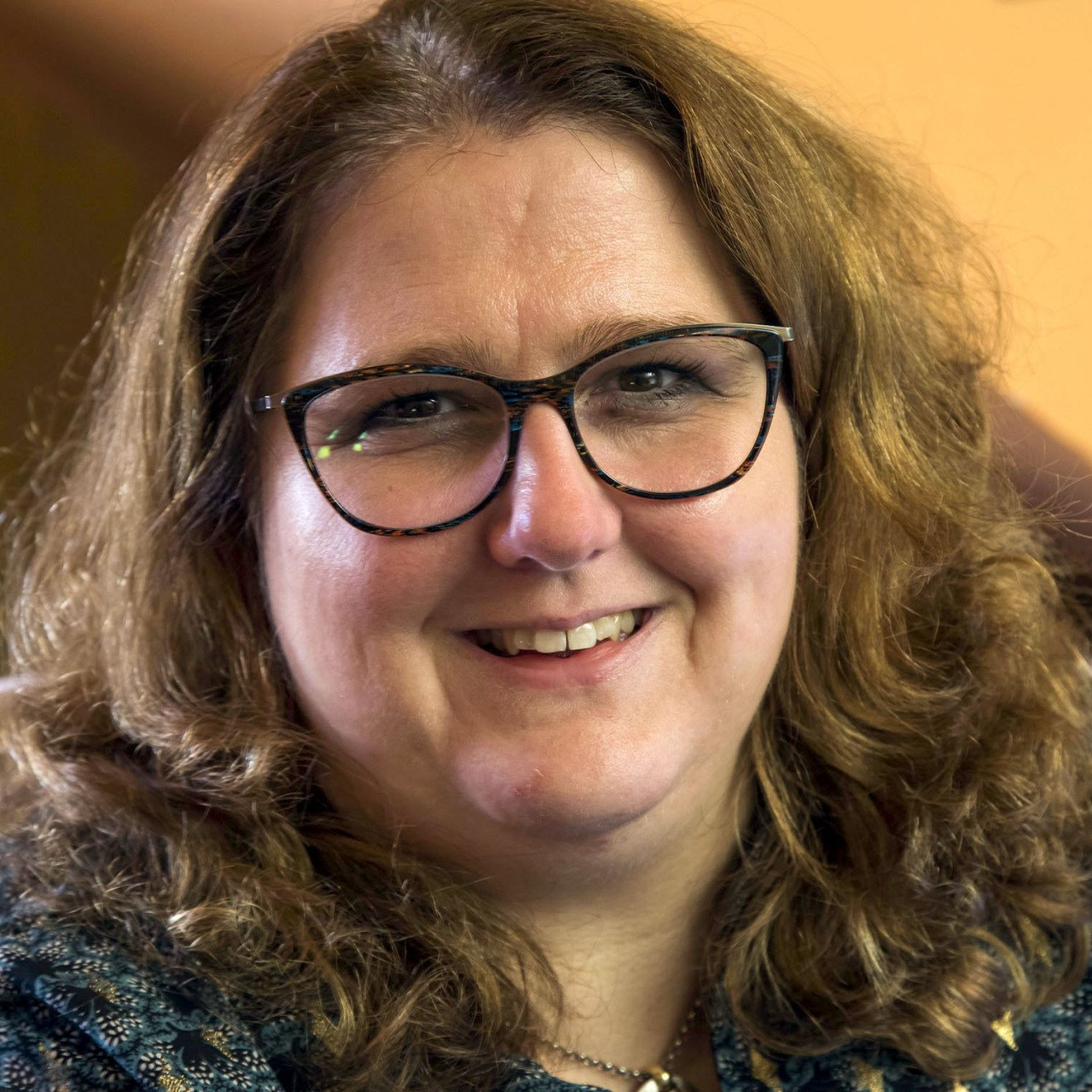 Porträt Bettina Görlitzer, sie lacht in die Kamera.