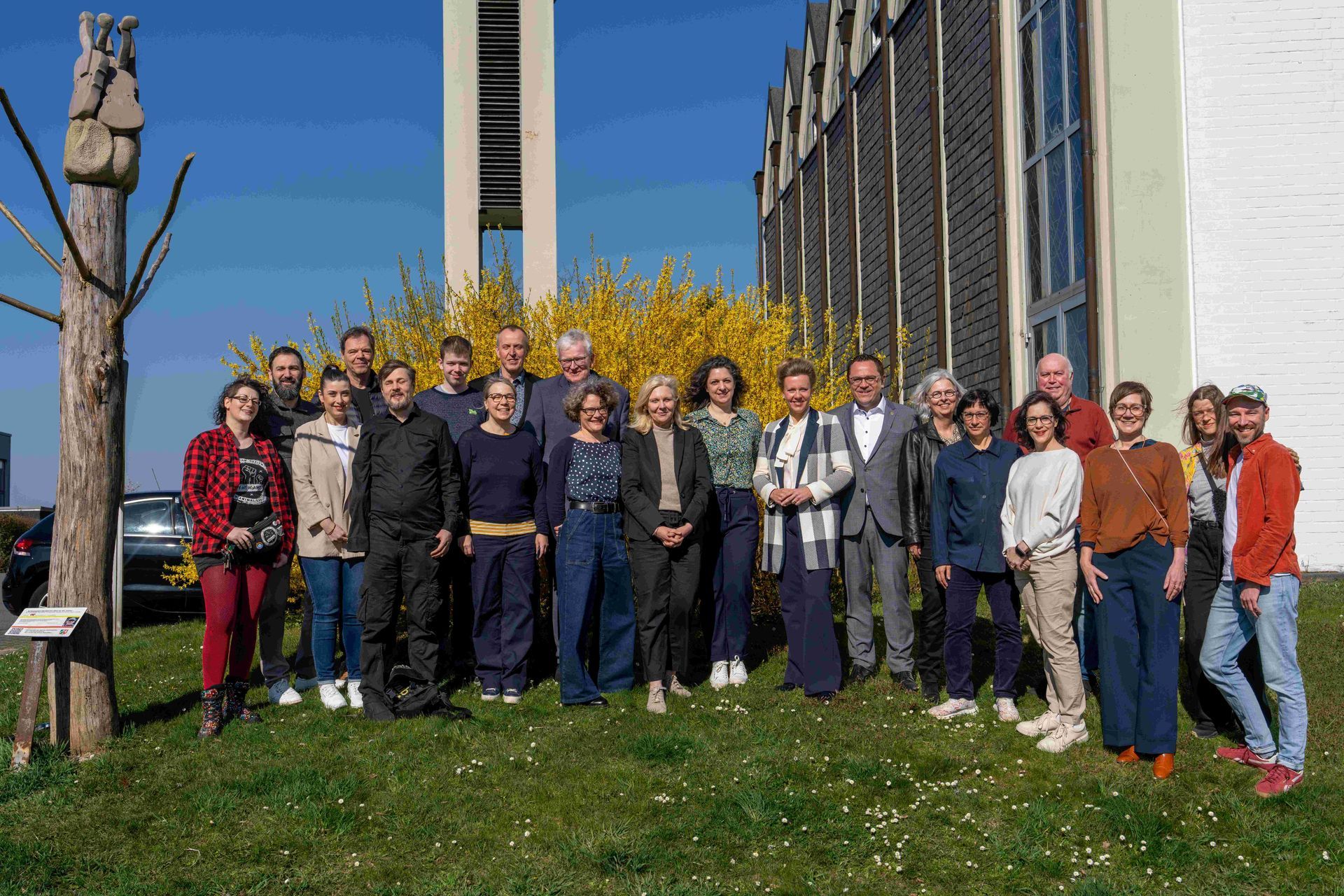 Auf dem Foto stehen alle 21 Akteur:innen der Tagung auf der Wiese vor dem Kulturort 8Giebel: alle Kulturlaborant:innen, die Kulturbegleiter:innen, die Teilnehmenden der Podiumsdiskussion mit Frau Ministerin Brandes, das Organisationsteam.