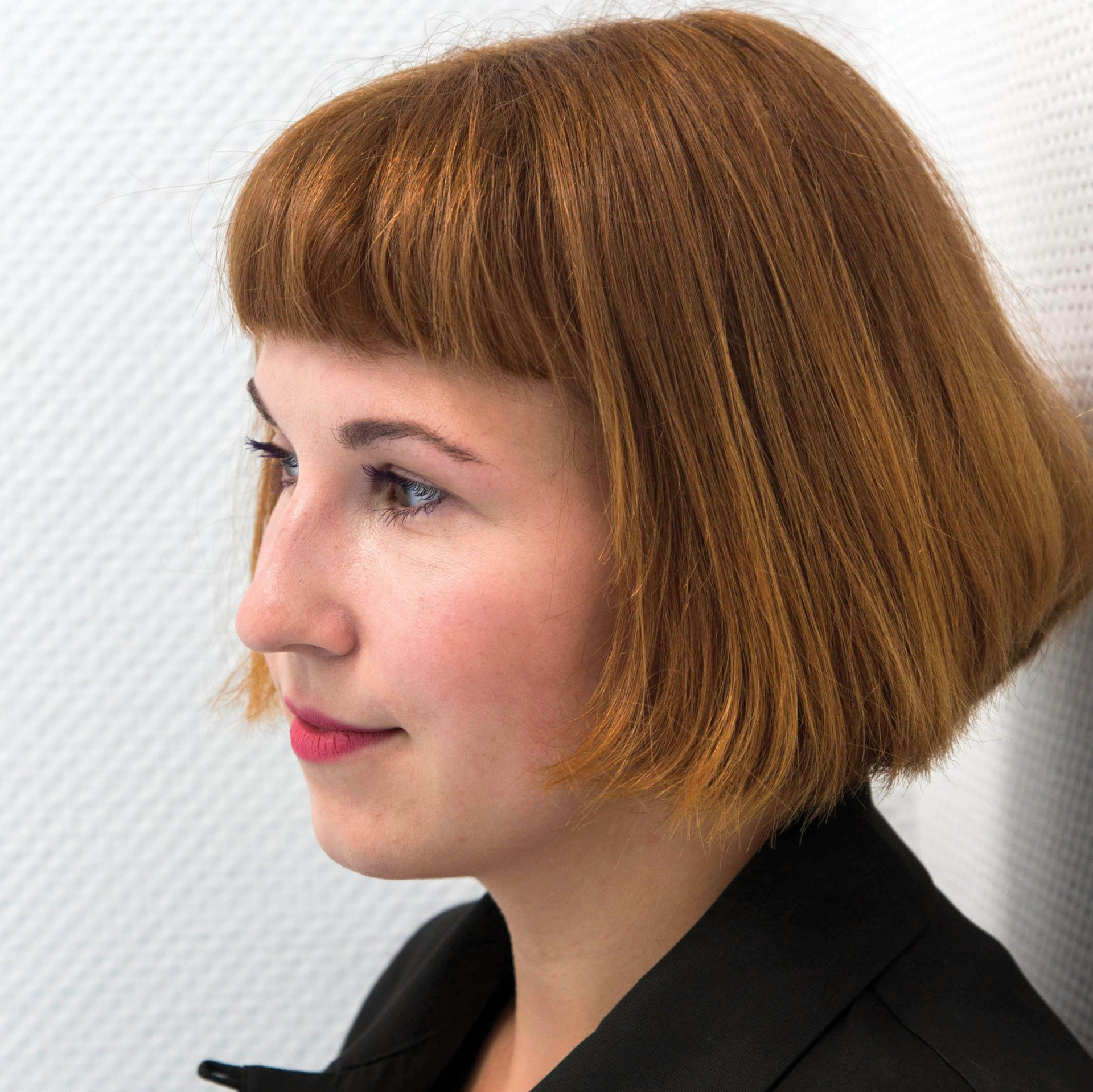 Großaufnahme das Gesichts von Jennifer Cierlitza von der Seite vor einem schlichen weißen Hintergrund.