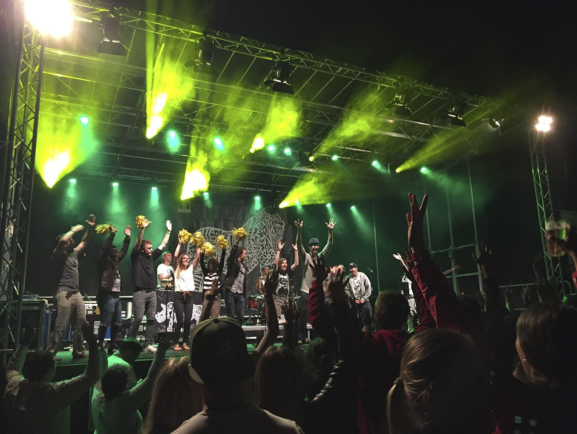 Bühne mit Musikern vor einem tanzenden Publikum.