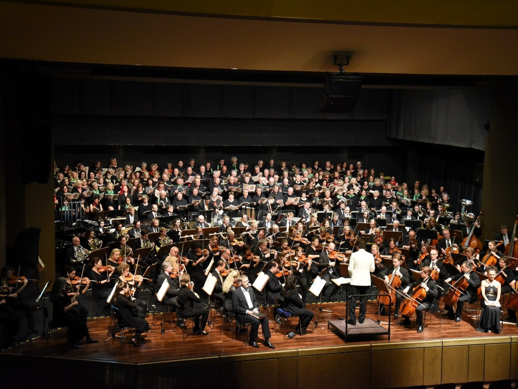 Orchester mit großem Chor auf einer Bühne