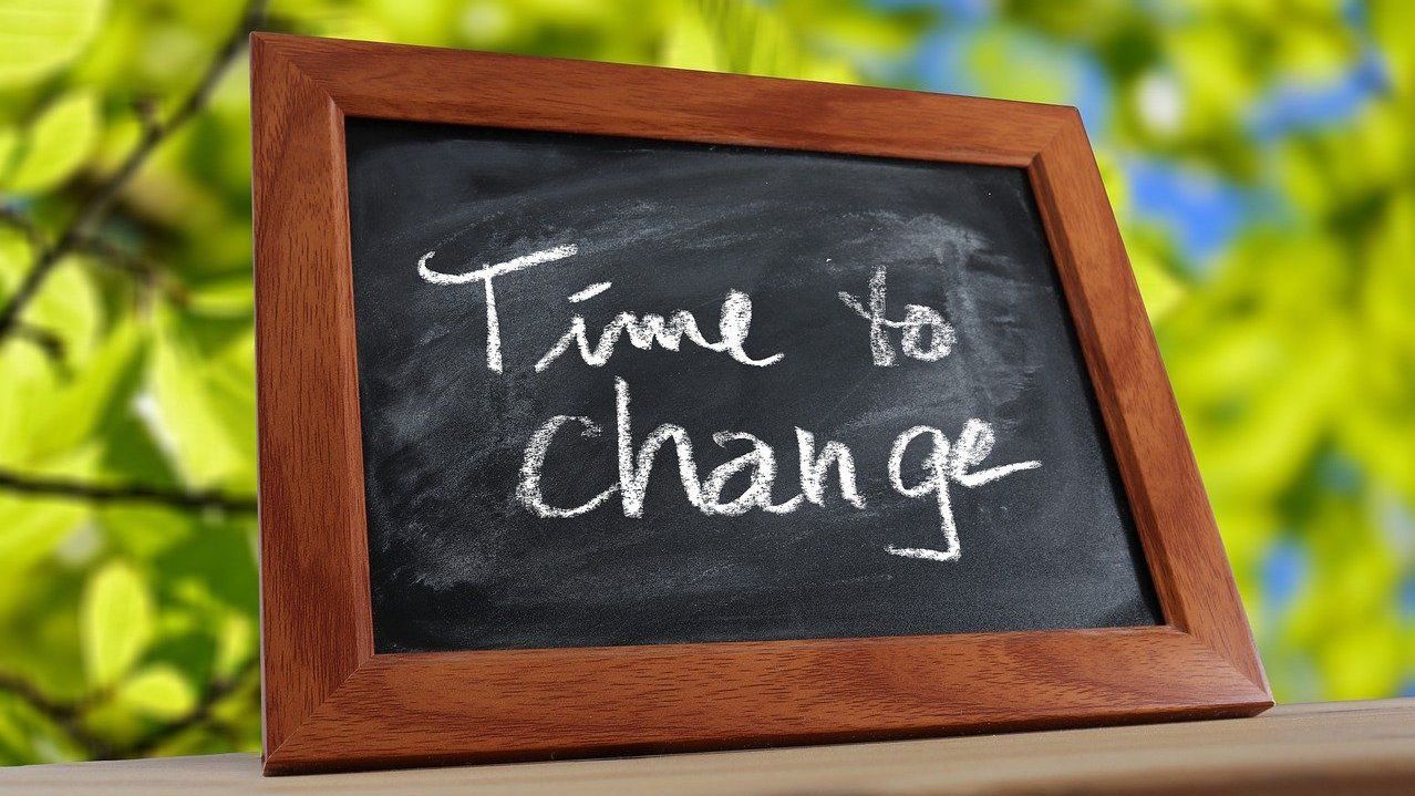 Schwarze Schiefertafel. Darauf steht in Kreide geschrieben: Time to Change