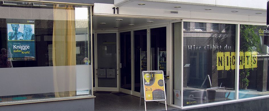 Foto Außenansicht des Dunkelcafe Siegens: Schaufensterfront mit Aufschrift