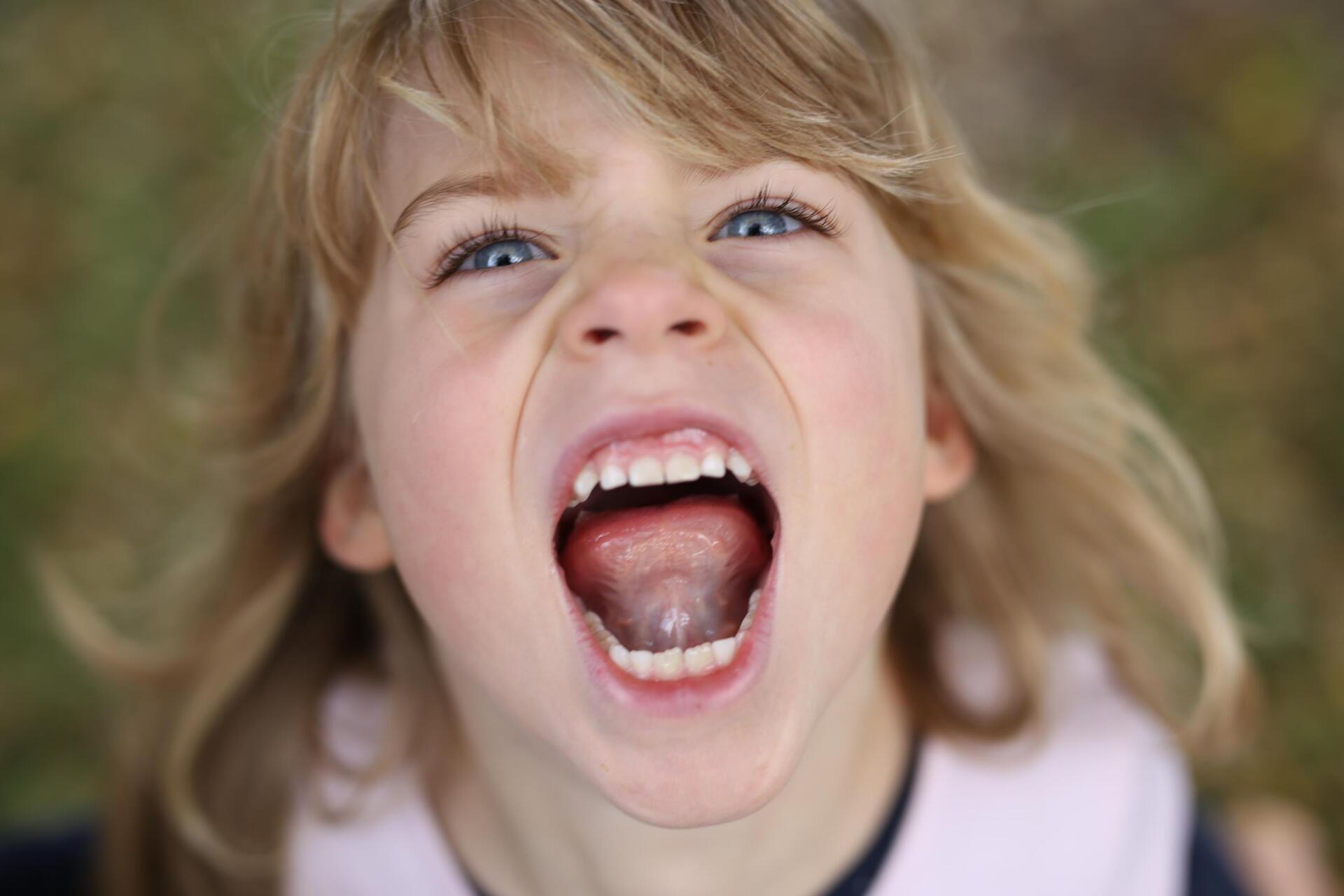 Kinder fühlen sich wohl bei Fotoshooting Kind lacht und schreit in die Kamera
