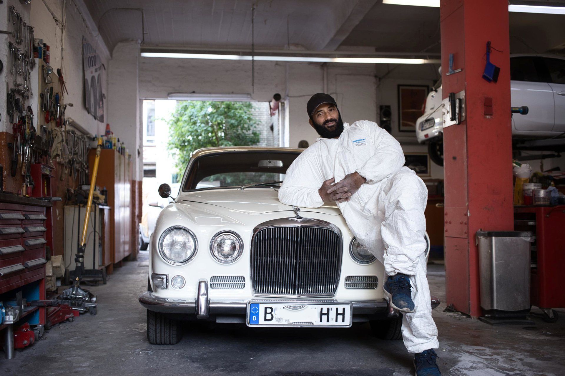 Jaguar XJ 6 Serie 1 und Restaurator Walid in typischer Kreuzberger Hinterhofwerkstatt für Kfz