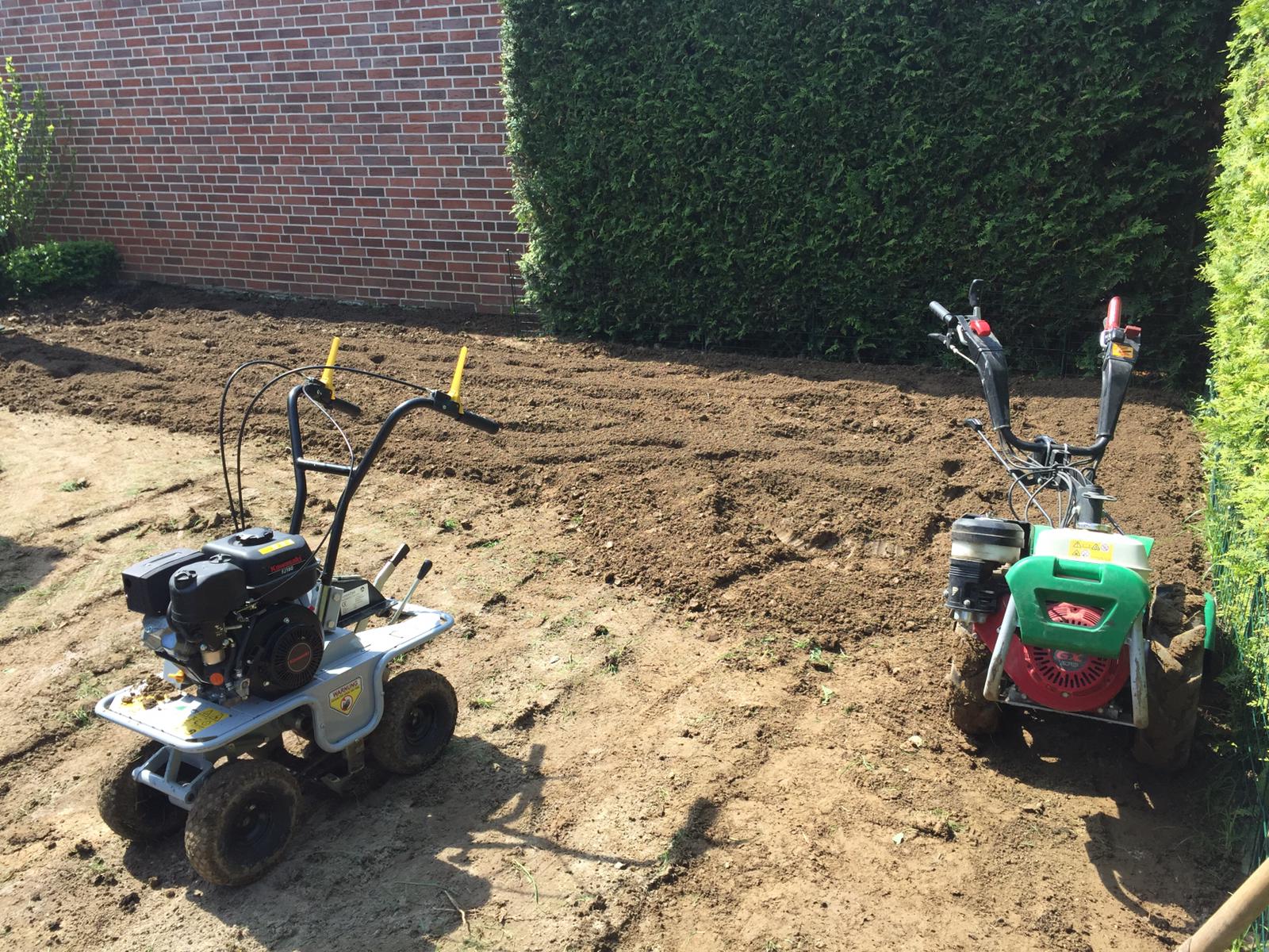 Ein Sodenschneider und eine Gartenfräse stehen in einem Garten