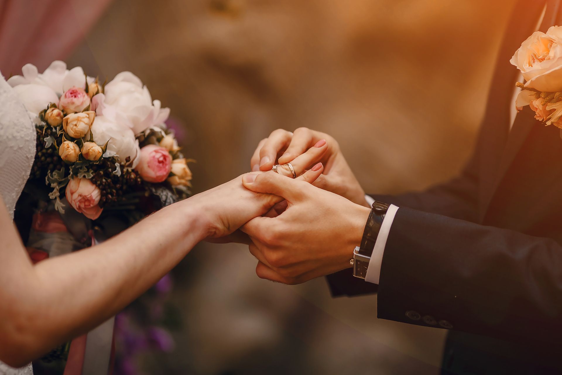 Gros plan sur les mains des mariés, échange des alliances - Wedding planner