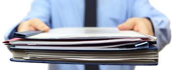 image: someone holding a pile of documents