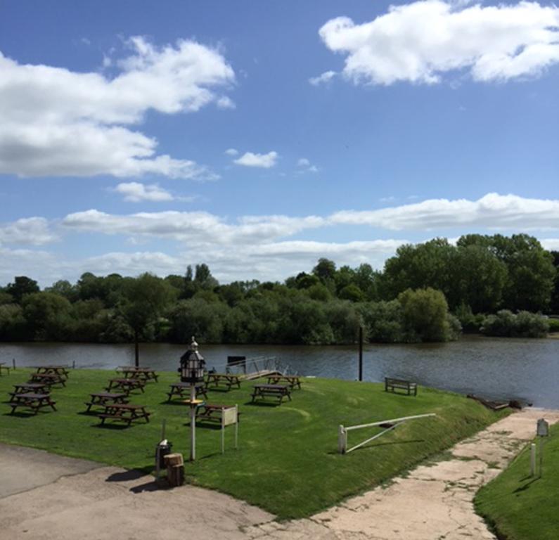 Riverside beer garden at the Lower Lode Inn, a tranquil setting on the River Severn near Tewkesbury, Gloucestershire