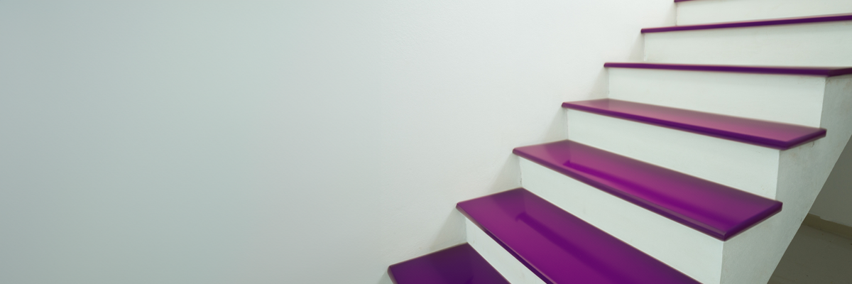 Treppe mit violett lackierten Stufen und weißer Wand