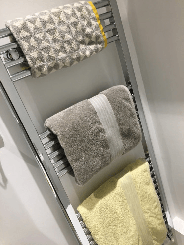 Freshly folded grey towel on heated rail after bathroom clean – Whitchurch, Shropshire