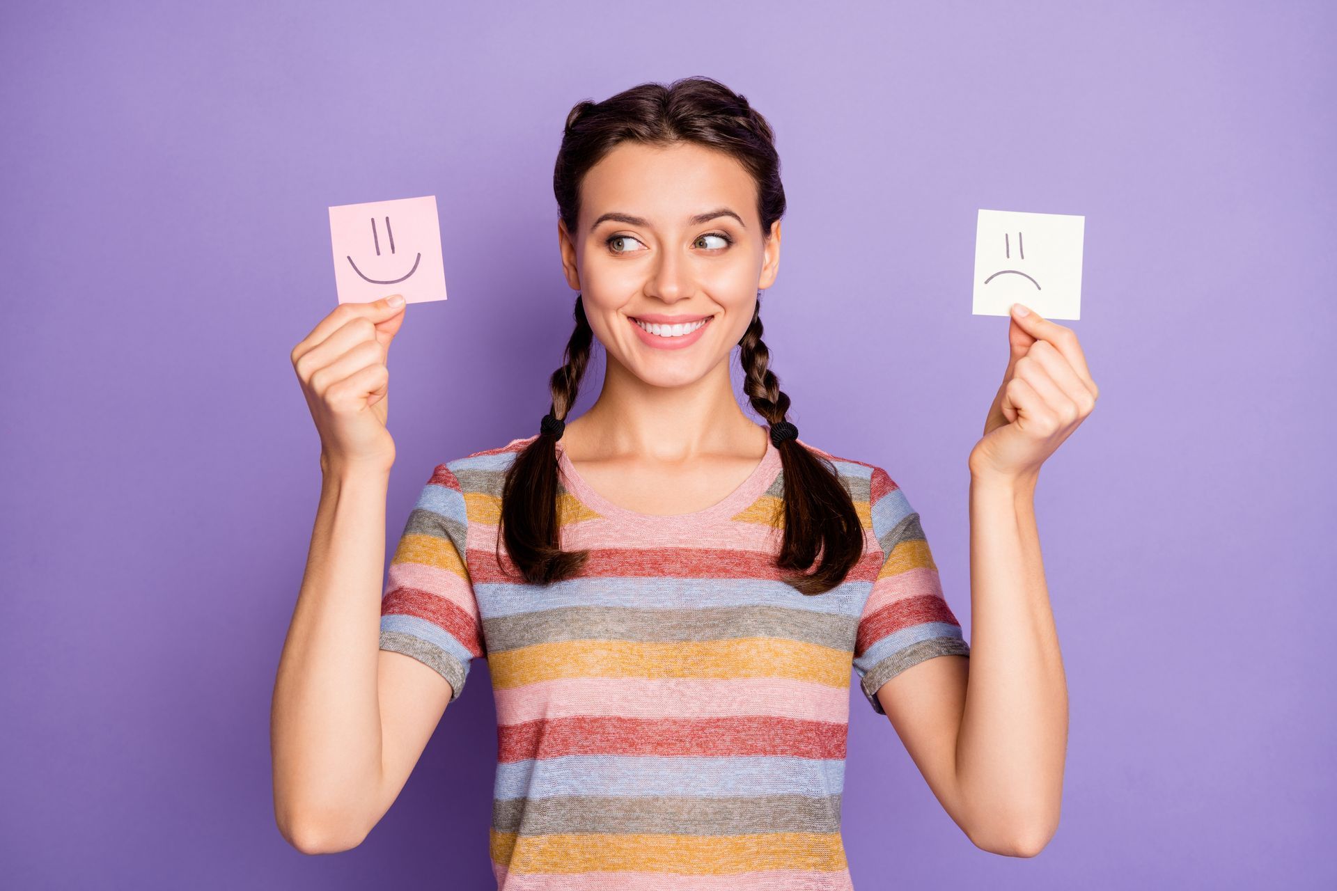 Jeune femme souriante hésitant entre 2 émotions Jeune femme souriante hésitant entre 2 émotions