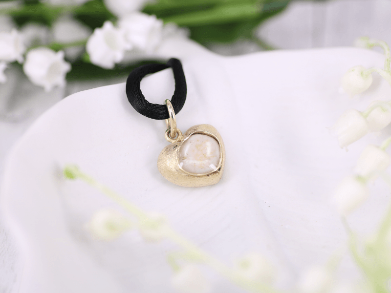 Unikatschmuck aus Gold mit einem Menschenzahn in Kunstharz eingegossen