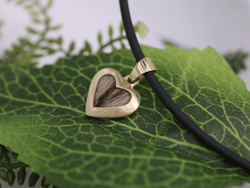 Kettenanhänger in Form eines symmetrischen Herzes aus Gold angeffertigt mit Tierhaaren