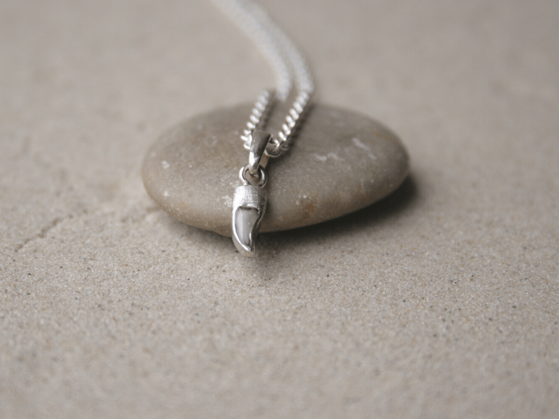 Unikatschmuck aus Gold mit einem Menschenzahn in Kunstharz eingegossen