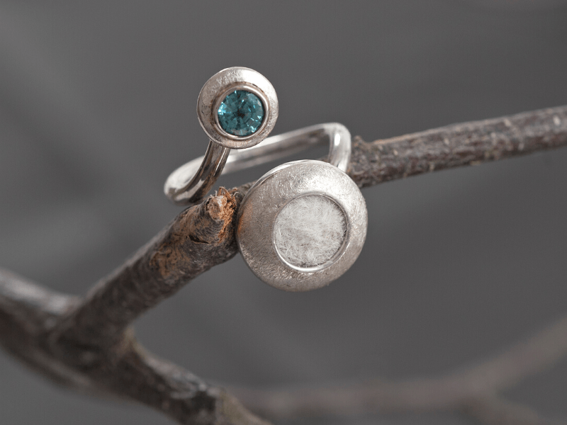 eleganter Ring mit einem blauen Zirkon und eingefilzten weißen Katzenhaaren
