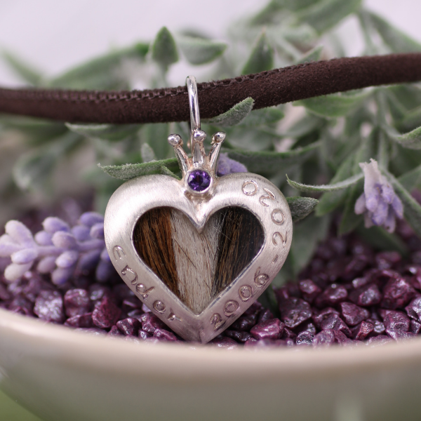 symmetrischer Kettenanhänger mit Tierhaaren mit Gravur am Rand, einer Krone und einem Amethyst