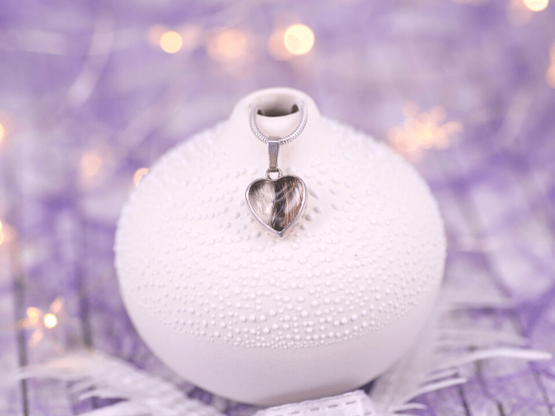 herzförmiger Kettenanhänger mit haarn unter einem Glasstein gefasst