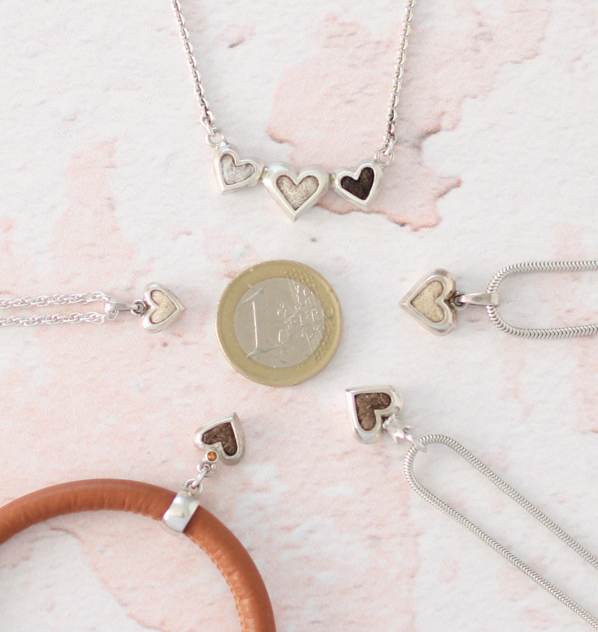 Schmuckstücke der Modellreihe Babyherz in verschiedenen Varianten. Mit eingefilzten Tierhaaren