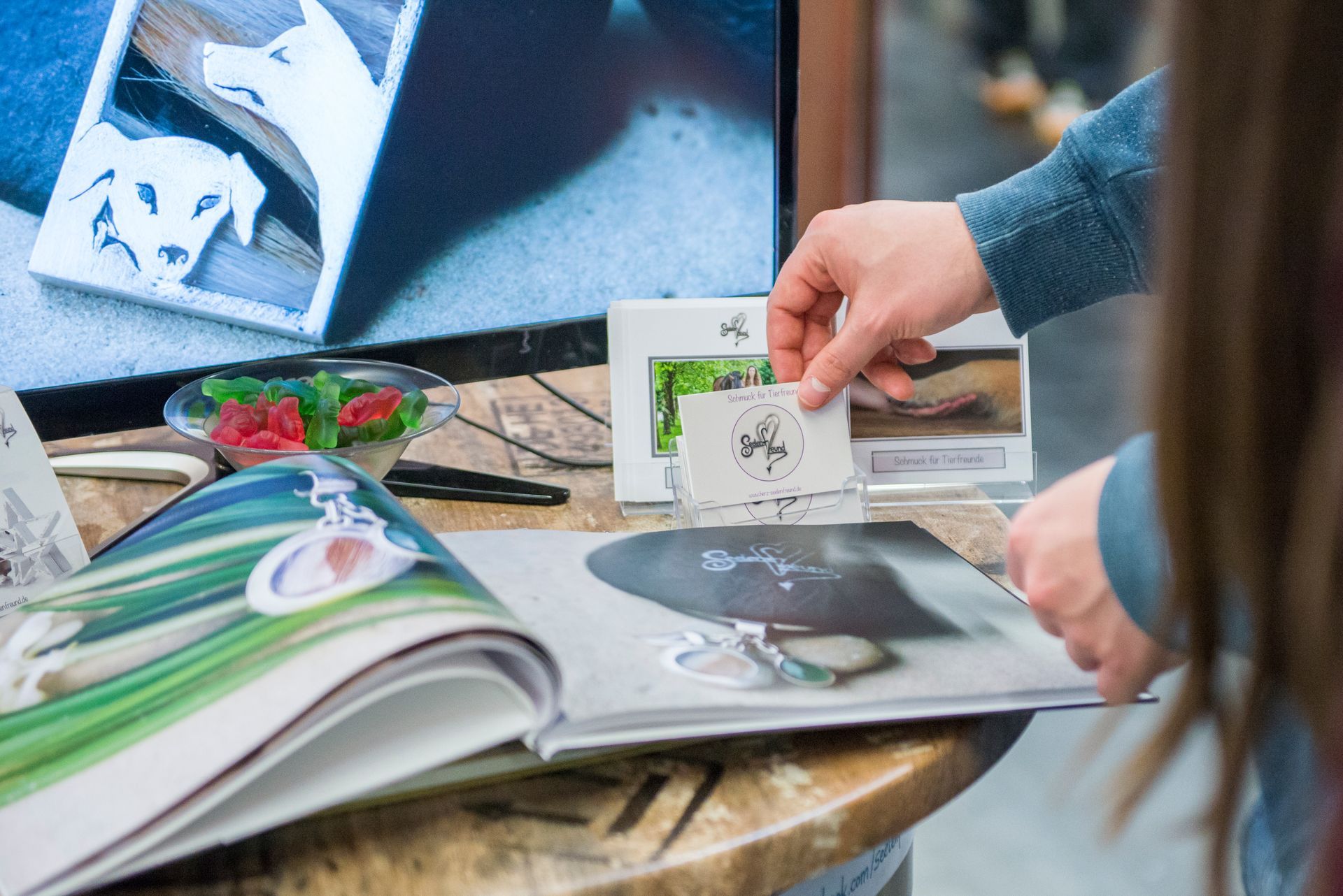 In der Mitte meines Messestandes auf der Conaumenta seht ein Messetisch der Firma Fasszination mit vielen Flyern, Visitenkarten und Fotobüchern, damit sich die Besucher über den Schmuck von Seelenfreund informieren können.
