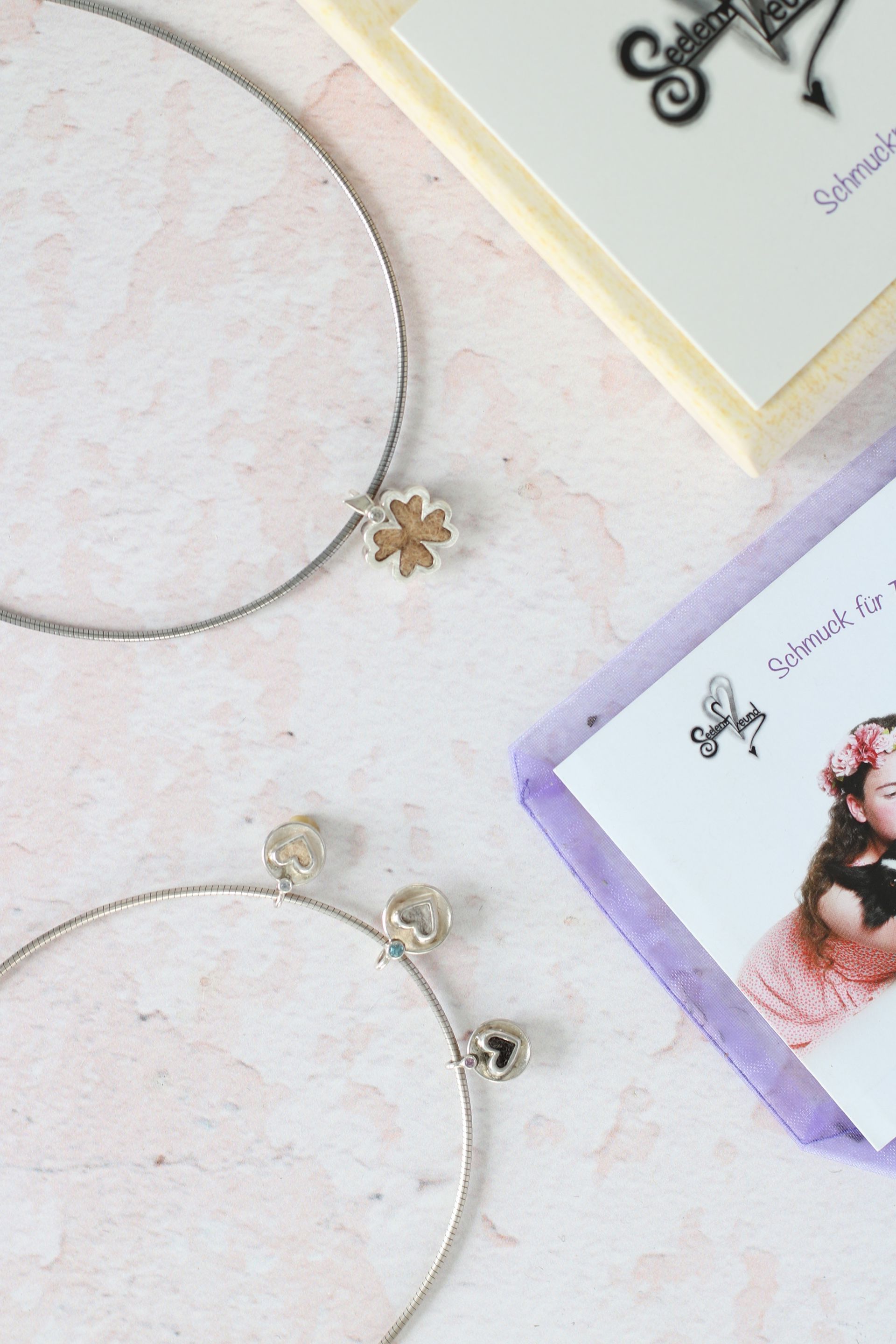 Tierhaarschuck in Form eines Kleeblatts und drei Medaillons in Herzform mit Haaren