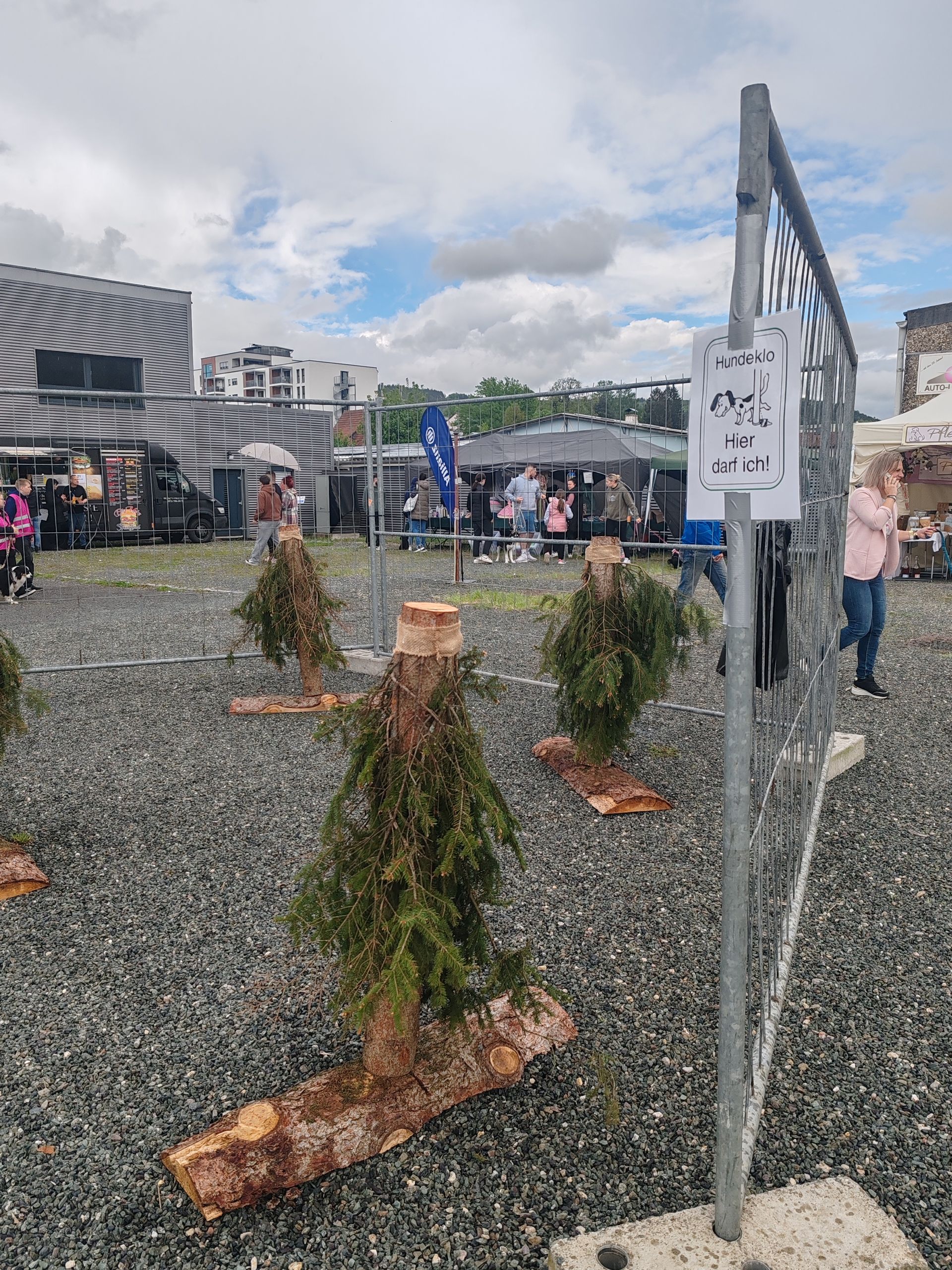 Holzstangen mit Zweigen als simulierter Baum, der die Hunde dazu einladen soll, dort ihr Geschäft zu verrichten. Eine sehr pfiffige Idee.