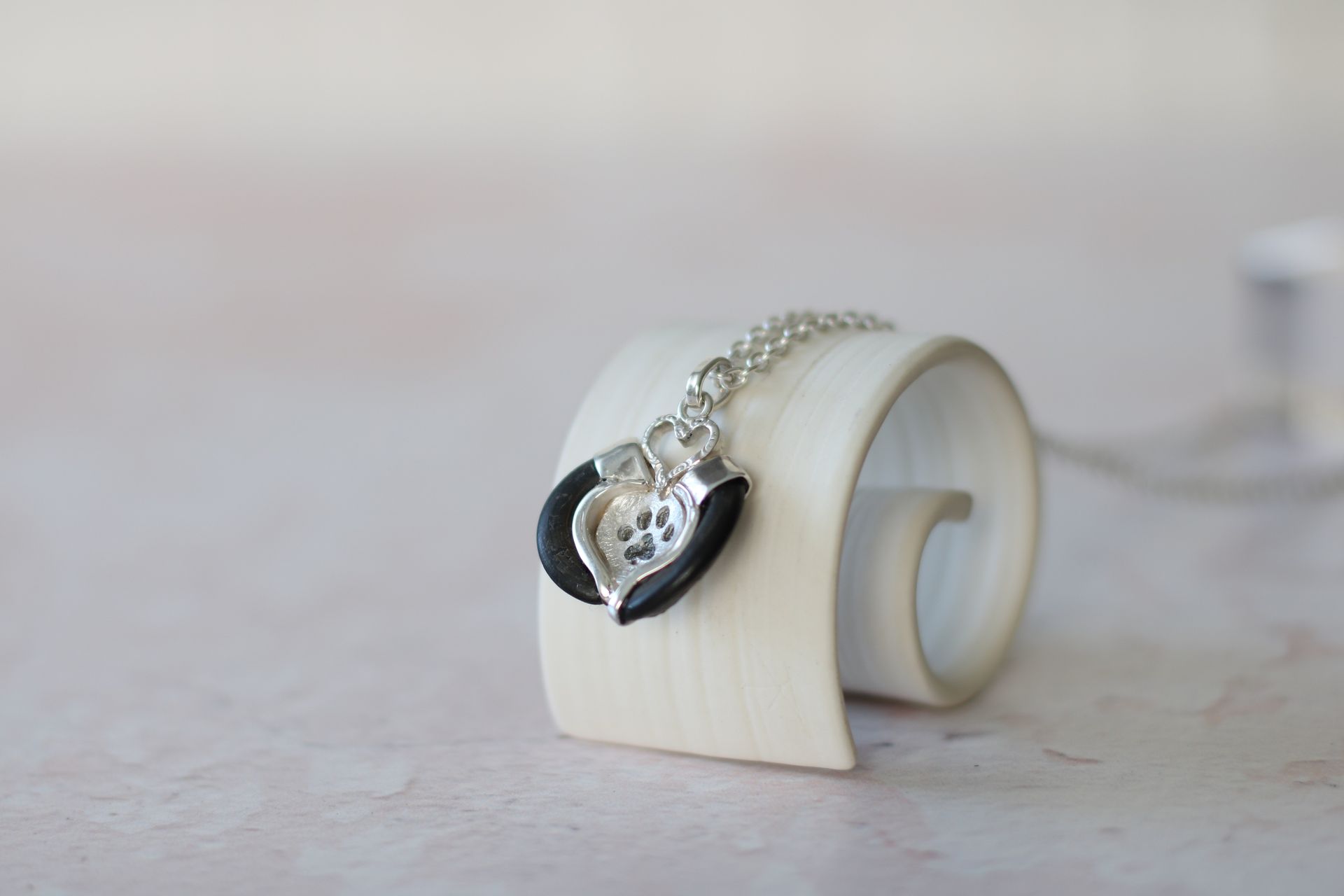 Kettenanhänger aus Silber, die Fassung wurde an die Form von zwei Krallen eines Hundes angepasst