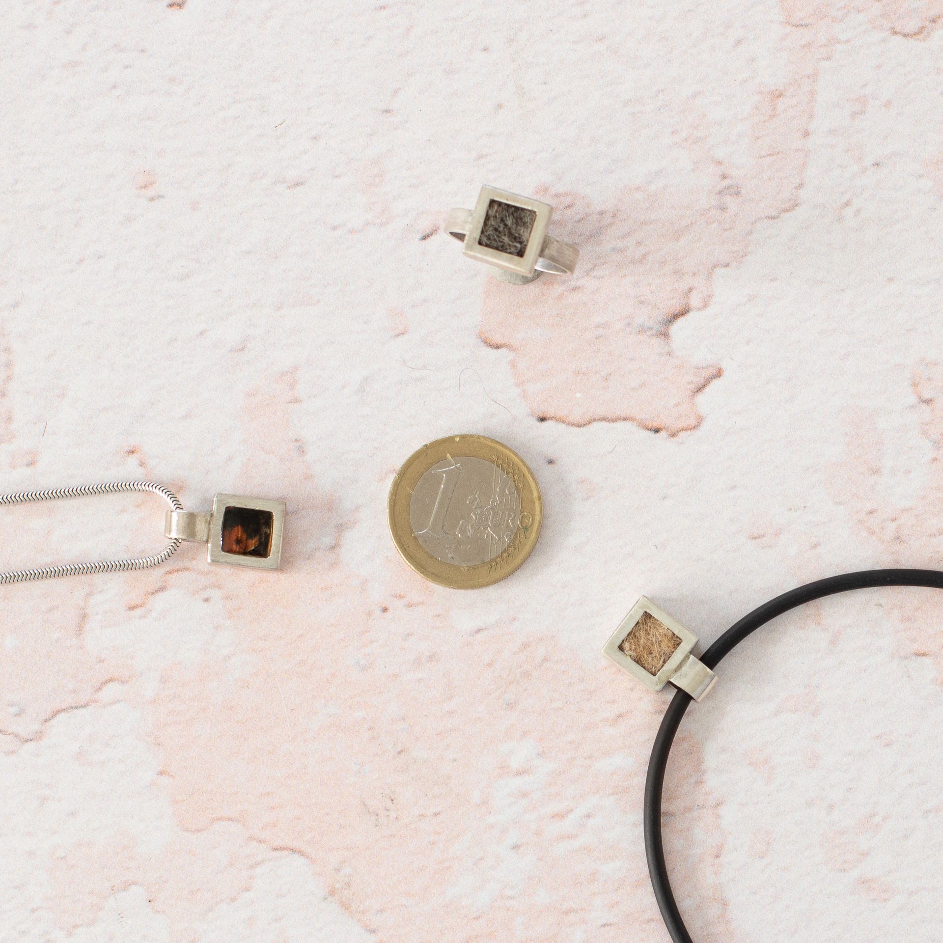 Das quadratsiche Modell Quadro als Ring und in Form von zwei kettenanhängern mit fest angelöteter Schlaufe.