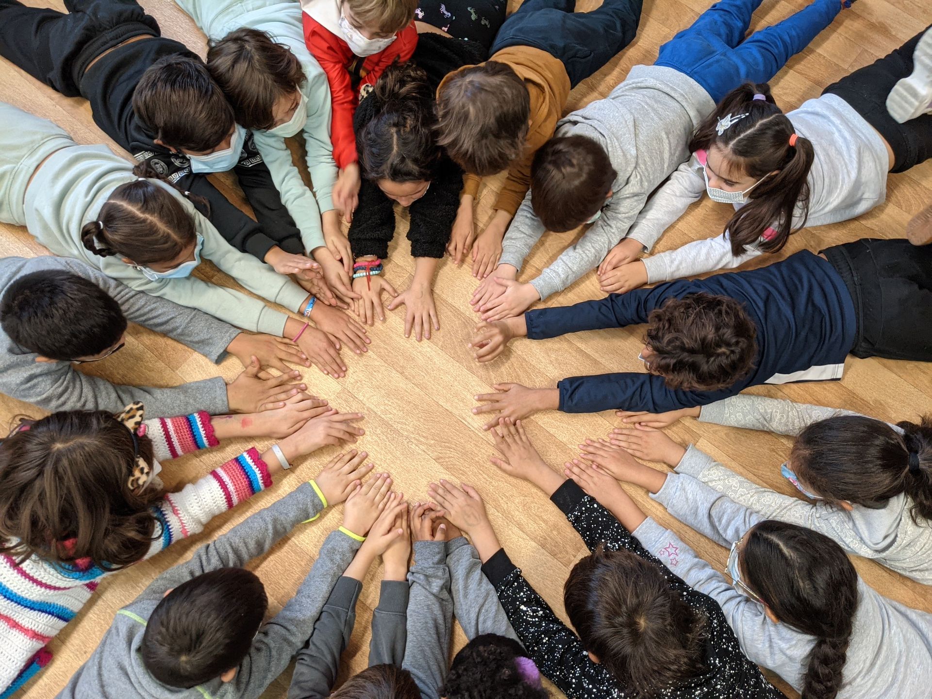 Imagen de niños y niñas con manos unidas formando un círculo