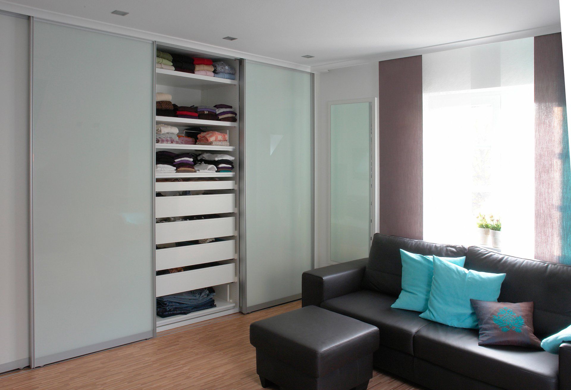 Kleiderschrank mit geöffneter Glastür von ip20 Möbel nach Maß.