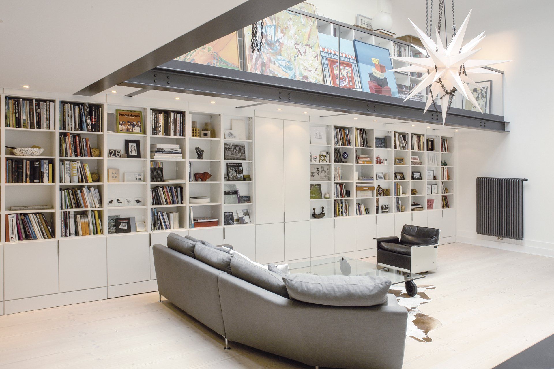 Ein Wohnzimmer mit Bücherregalen und Schränken von ip20