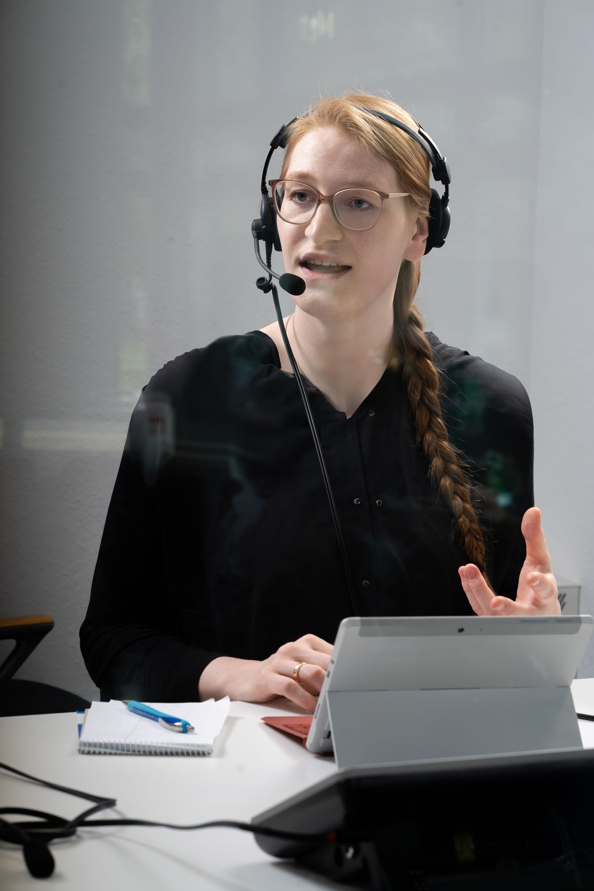 Wichtiges Dolmetschequipement: Kopfhörer, Notizbuch und ein Mikrofon