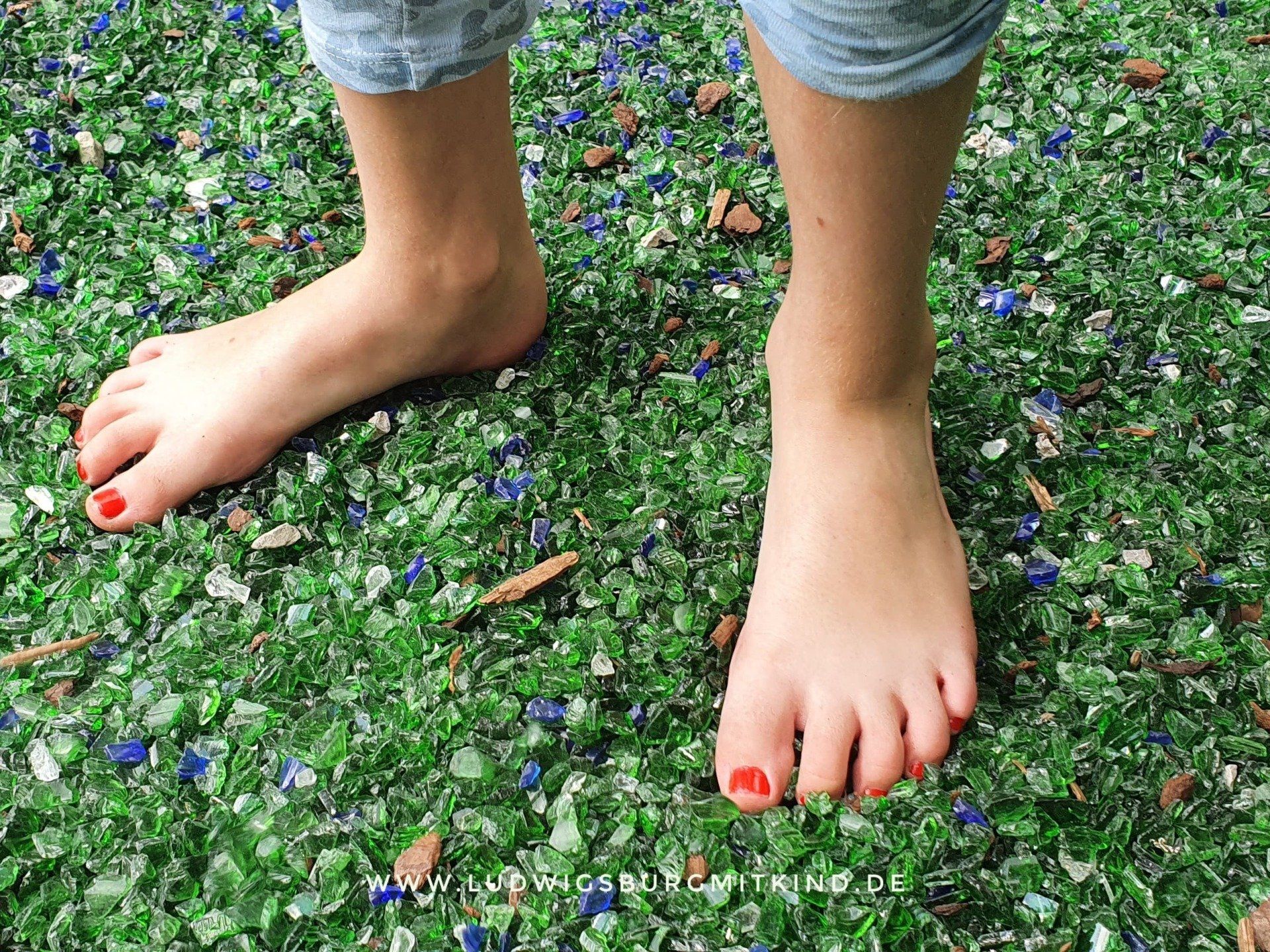 Ein Kind läuft auf dem Barfußpark in Dornstetten über Glasscherben.