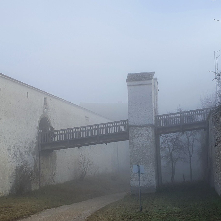 Die Burgmauer mit dem Steg der Burg Wildenstein its im Nebel kaum zu erkennen.