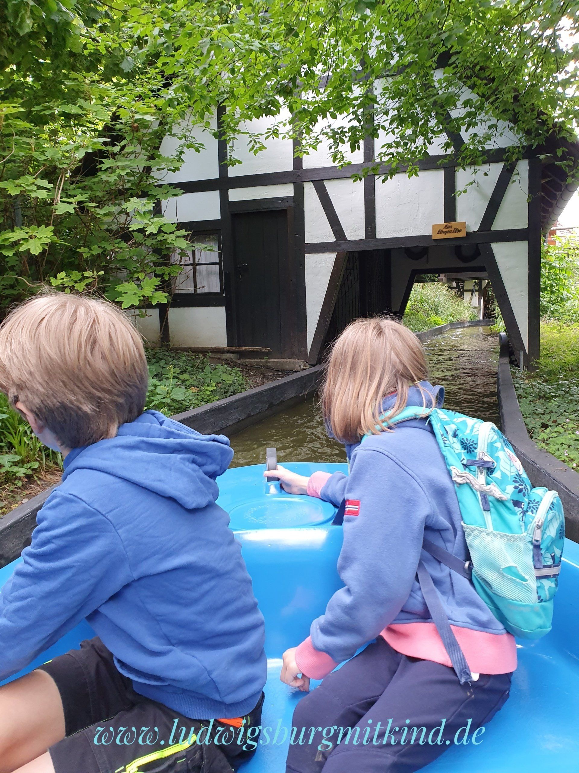 Kinder fahren in einem Boot durch den Tunnel im Märchengarten des Blühenden Barocks Ludwigsburg.